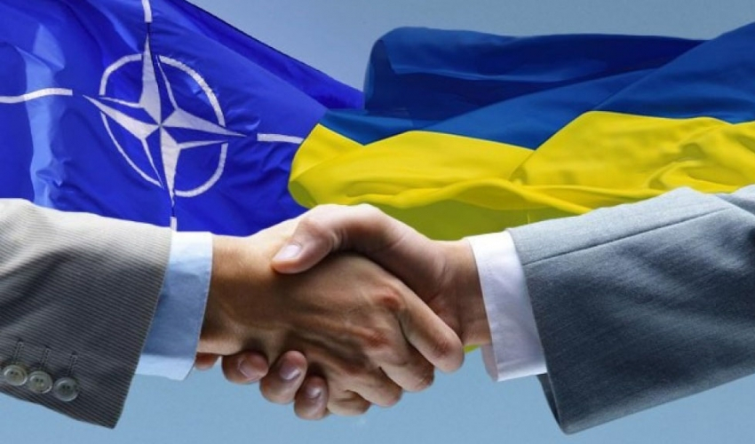 Заставка: рукопотискання на тлі прапорів України і НАТО