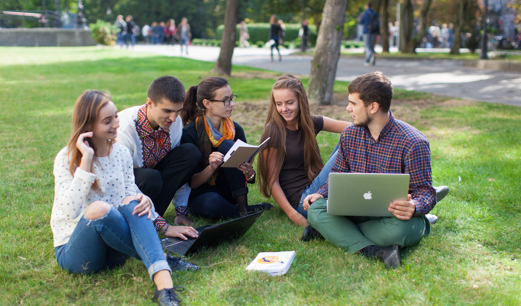 фото студентів, які сидять на травичці в парку