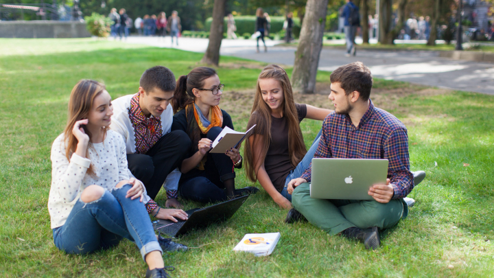 фото студентів, які сидять на травичці в парку
